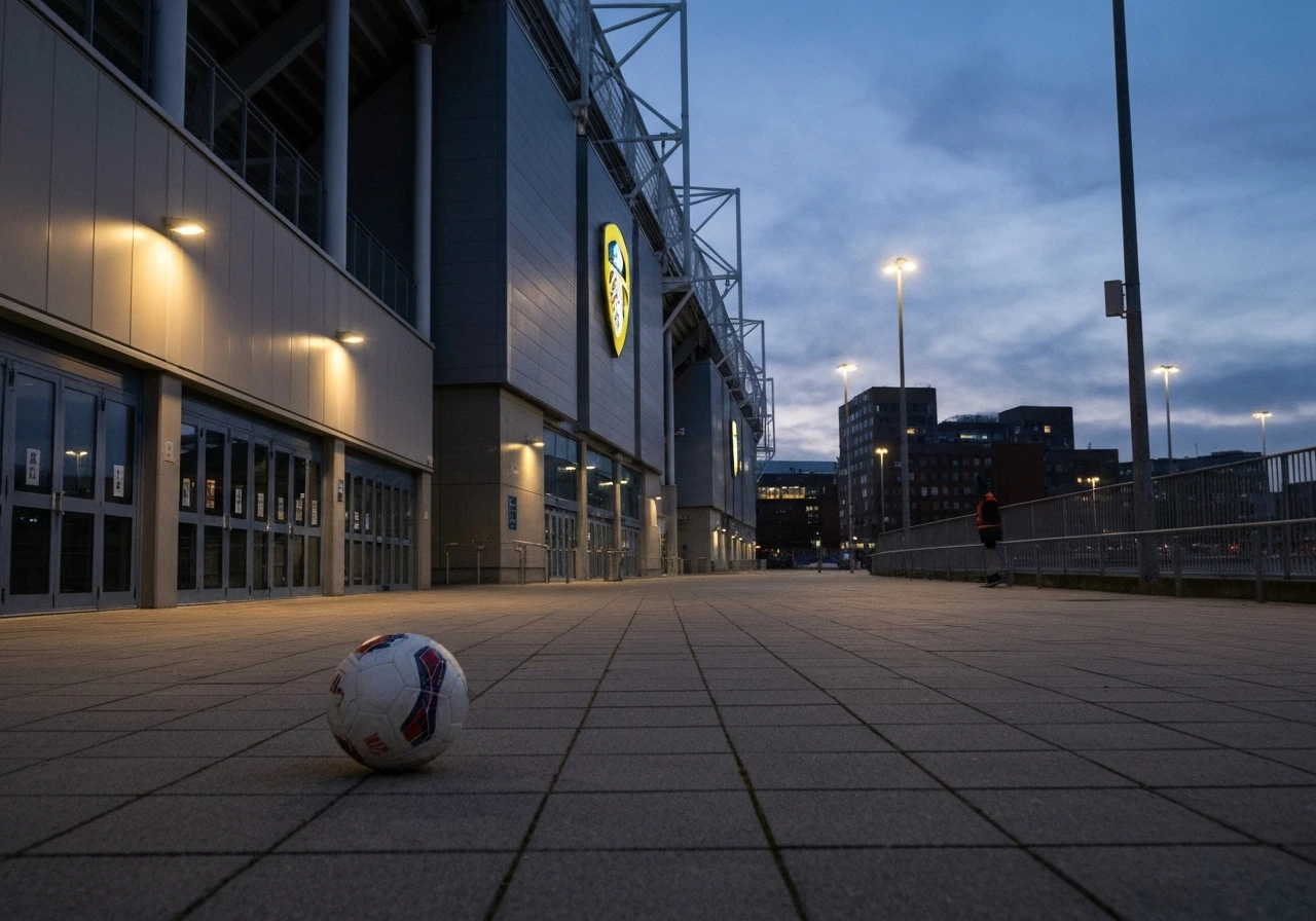 Leeds United stadium facade with a football resting near the entrance at dusk