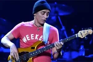 Benny Rietveld performing on stage playing bass guitar